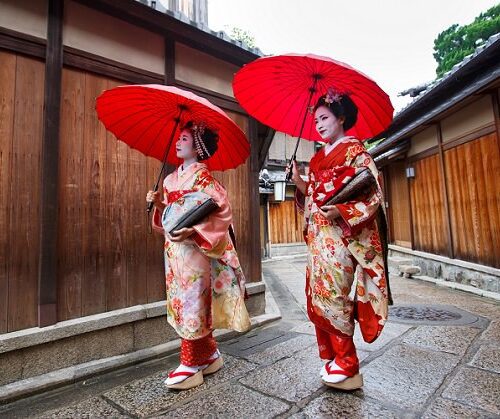 Two Maiko girls walking in old street together
